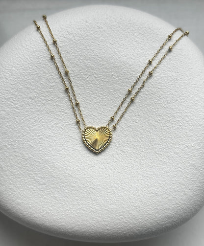 Diese romantische und elegante goldene Liv Halskette ist mit einem zierlichen Herzanhänger geschmückt. Die Kette kann elegant allein getragen oder mit anderen Ketten kombiniert werden. Sie ist aus Edelstahl gefertigt und mit 14K Vergoldung beschichtet.