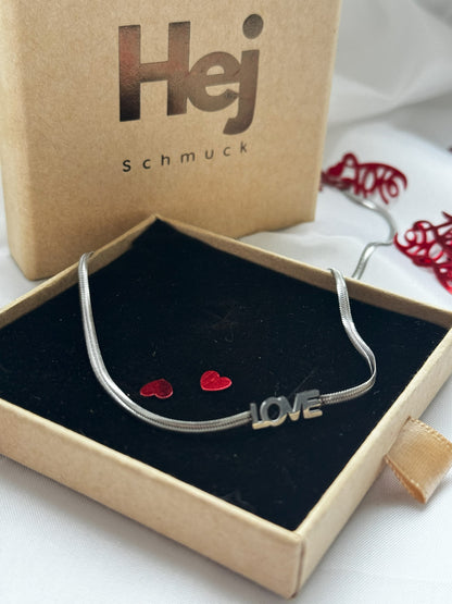 Mit der Elle Silbernen Edelstahlkette, verziert mit der bezaubernden Aufschrift 'Love', trägst du nicht nur ein Schmuckstück, sondern eine Aussage. Ihre subtile Einfachheit macht sie vielseitig und perfekt für den Alltag, während die tiefgreifende Bedeutung des Wortes 'Love' einen Hauch von Emotionalität hinzufügt.